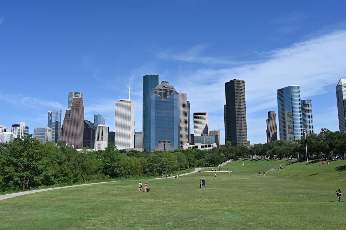 The downtown Houston, Texas skyline viewed from a green park on a clear day.